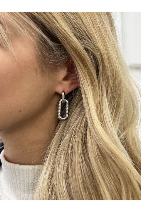 Ribbed Oval Hoop Earrings In Silver by SVNX