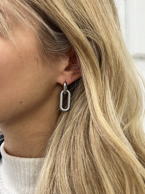 Ribbed Oval Hoop Earrings In Silver by SVNX